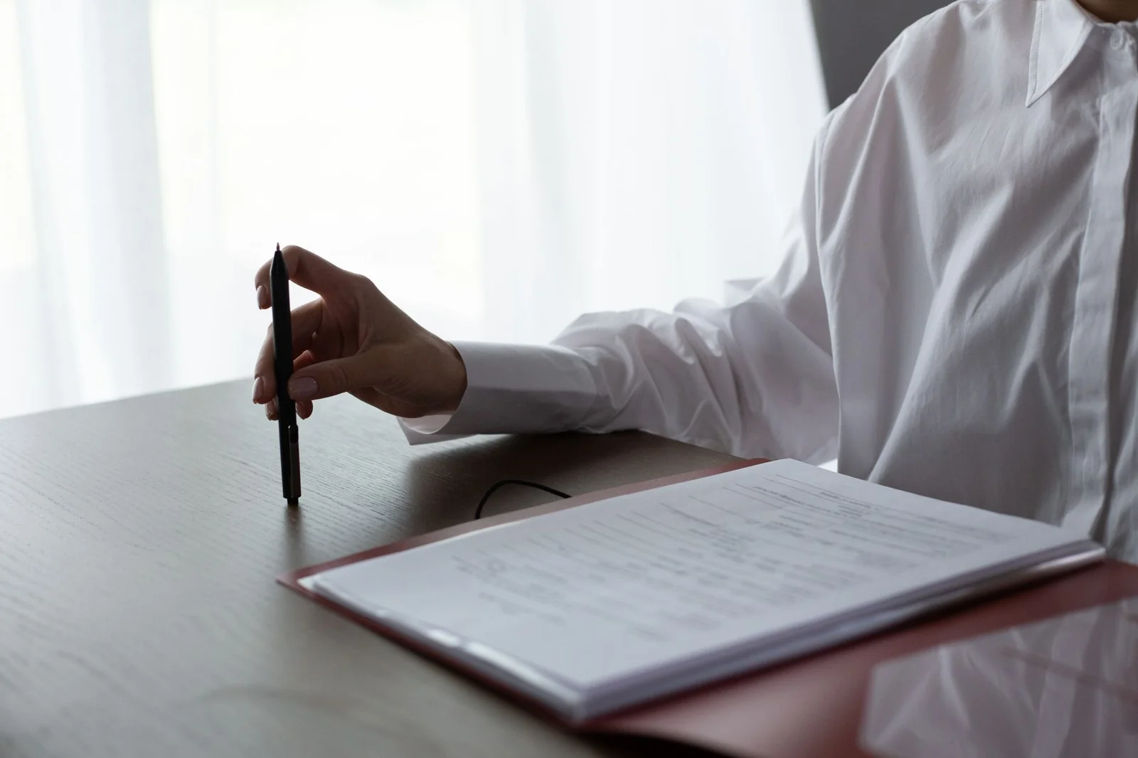 Responsable achats qui compare des documents fournisseurs sur un bureau